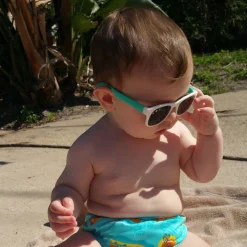 Óculos de Sol Infantil Flexível com Garantia de 1 ano Roshambo Baby - Bebê com óculos azul e branco na piscina