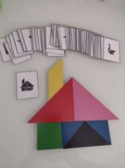 Uma casa formada por peças do jogo de raciocínio Tangram, e logo acima os cartões com outras formas copiar